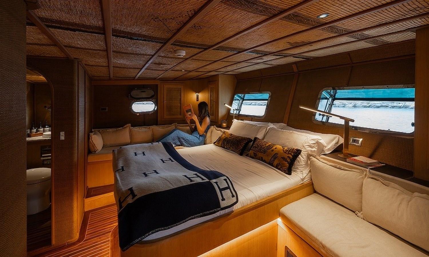 a person sitting on a bed aboard CUSTOM MADE MOTORSAILOR Yacht for Sale