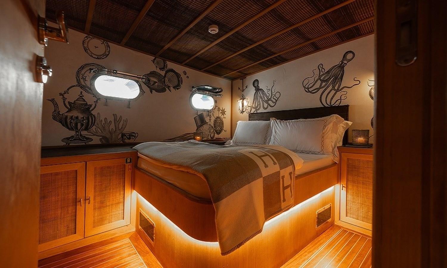 a bedroom with a bed and a lamp aboard CUSTOM MADE MOTORSAILOR Yacht for Sale