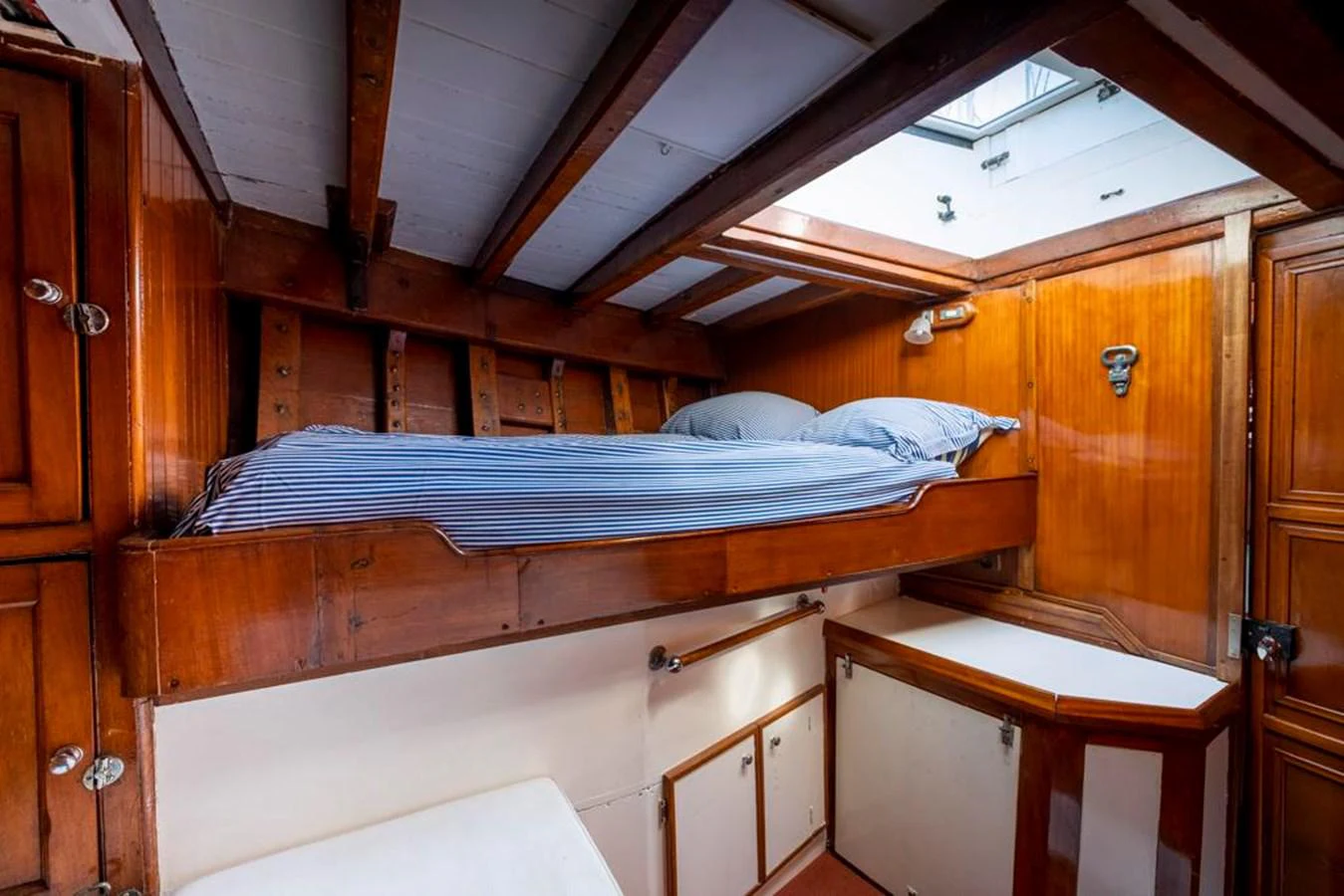 a bed with a blue sheet aboard JULIETTE Yacht for Sale