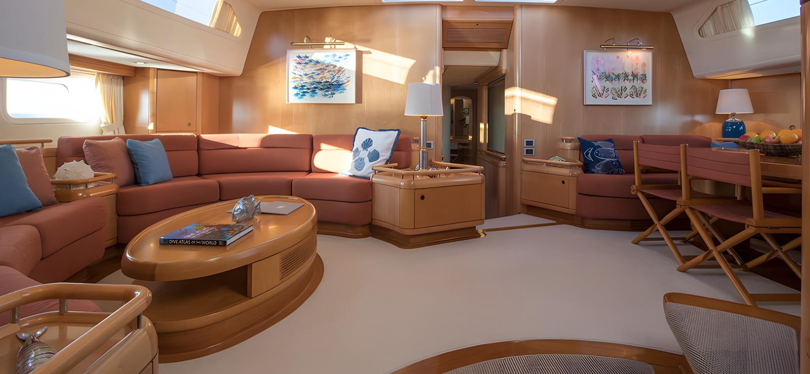 a living room with a large bed and a table aboard NAOS Yacht for Sale