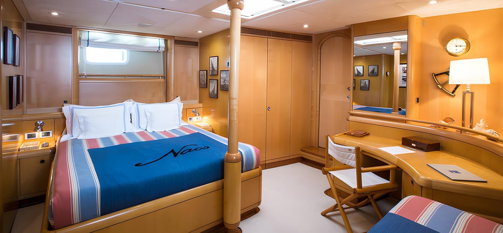 a room with a bed and desk aboard NAOS Yacht for Sale