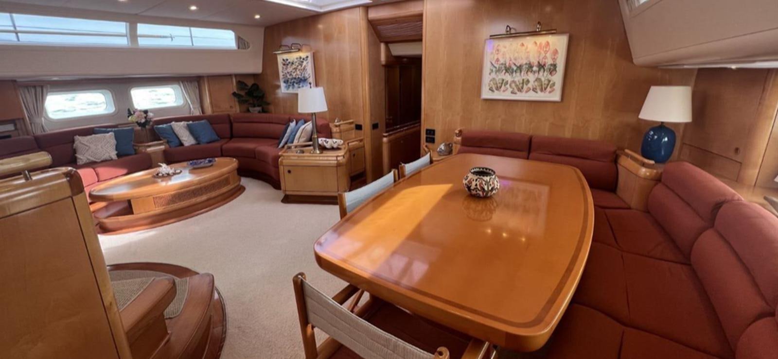 a living room with a table and couches aboard NAOS Yacht for Sale