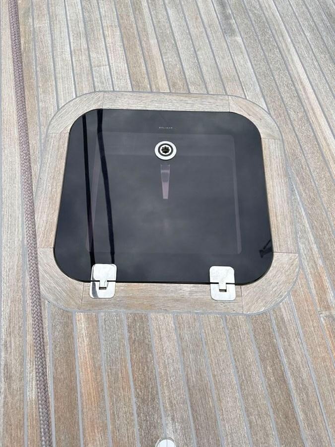 a black cell phone on a wooden surface aboard KARMA Yacht for Sale