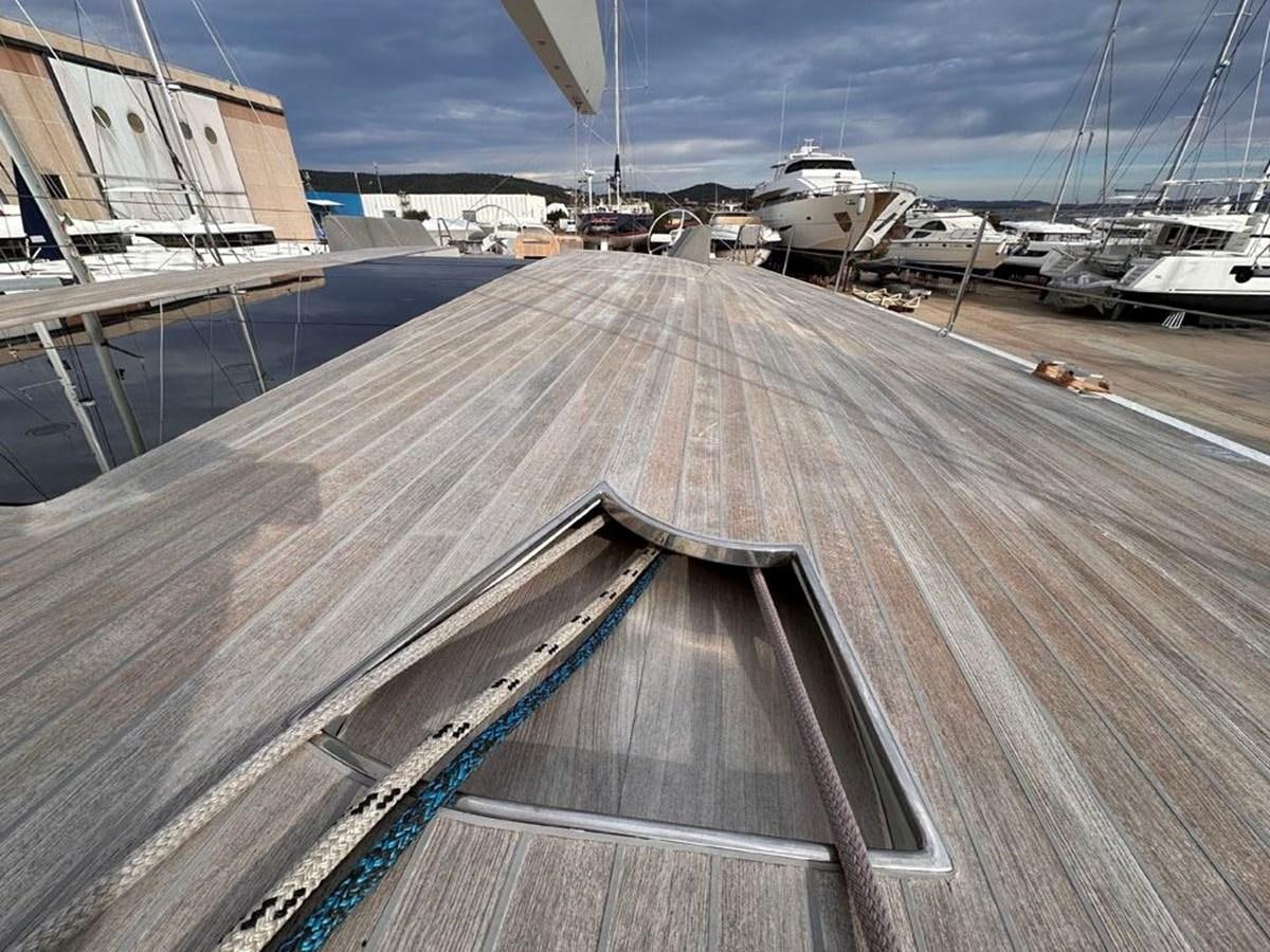 a wooden deck with a railing and boats on it aboard KARMA Yacht for Sale