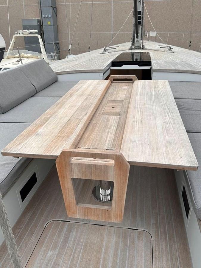 a wooden table with a metal frame aboard KARMA Yacht for Sale