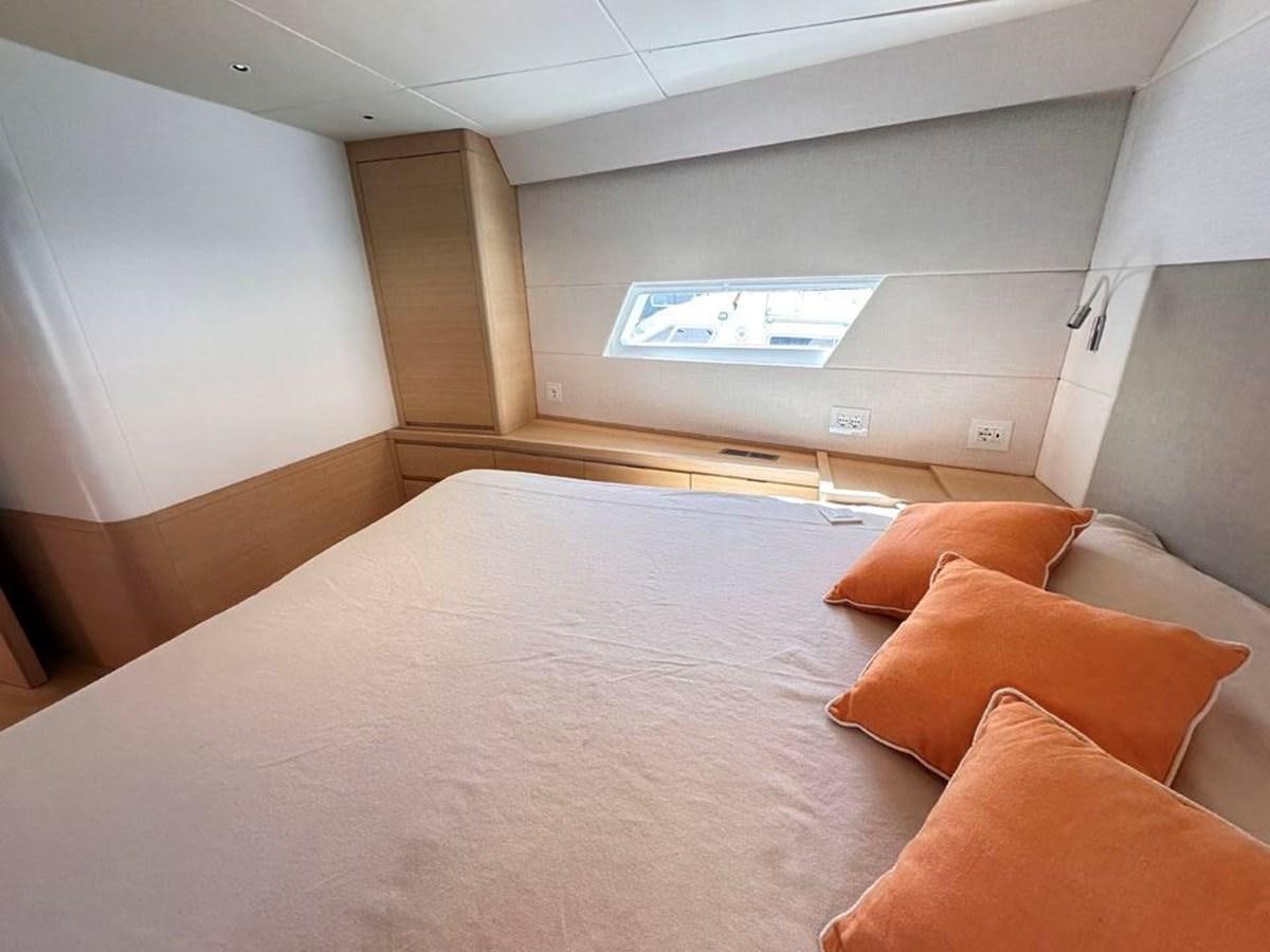 a bed with a white bed spread aboard KARMA Yacht for Sale