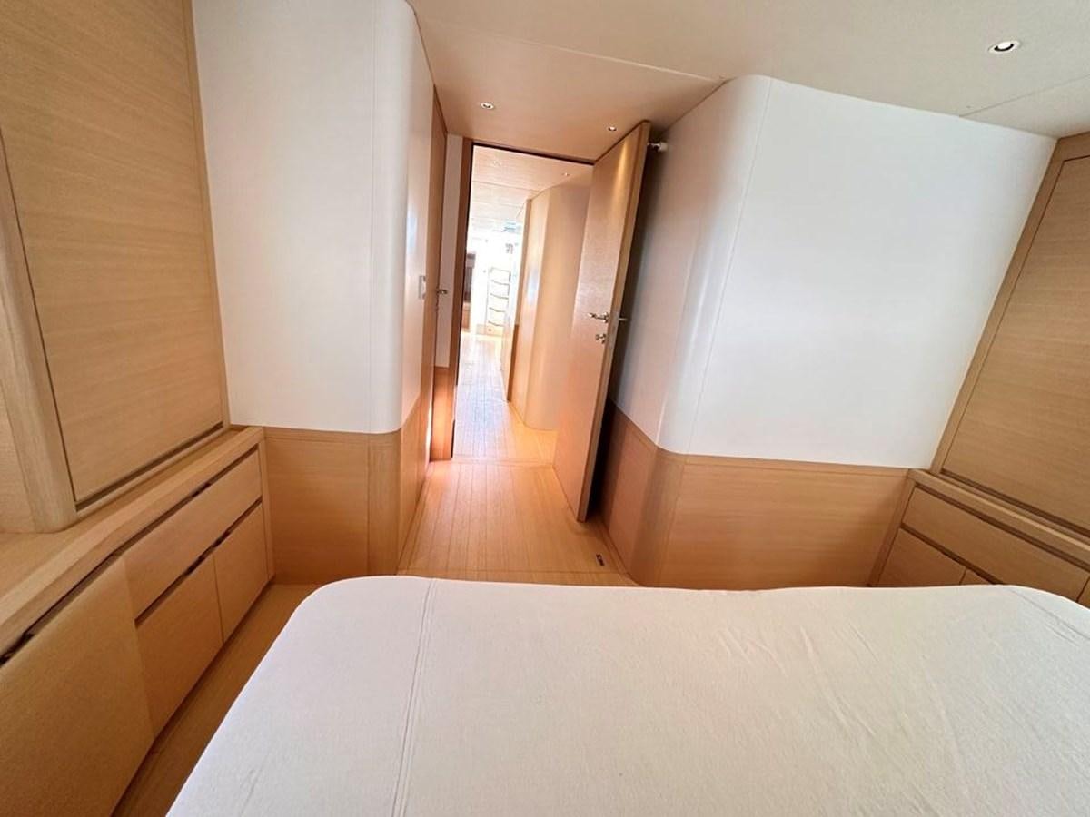 a room with a white bed and wooden cabinets aboard KARMA Yacht for Sale