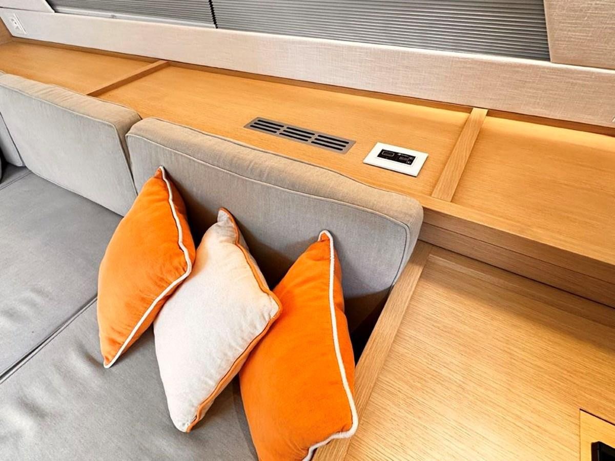 a couch with orange pillows aboard KARMA Yacht for Sale