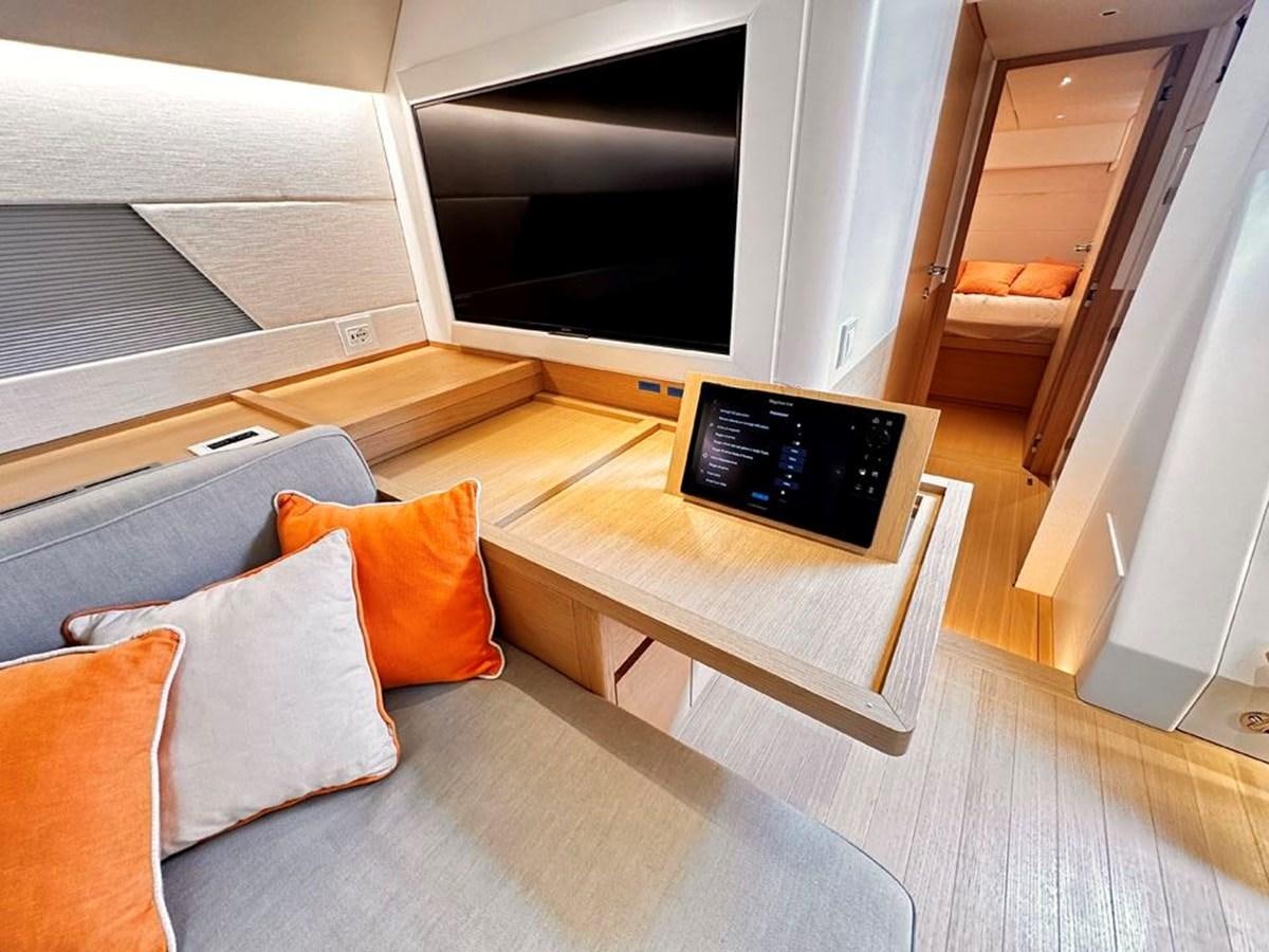 a living room with a tv and furniture aboard KARMA Yacht for Sale