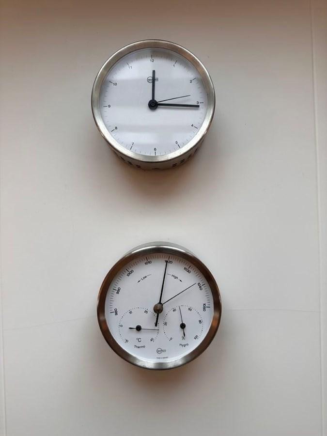 a couple of clocks on a wall aboard KARMA Yacht for Sale
