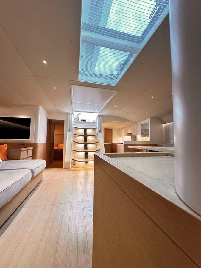 a room with a wood floor and a white couch and a white wall aboard KARMA Yacht for Sale