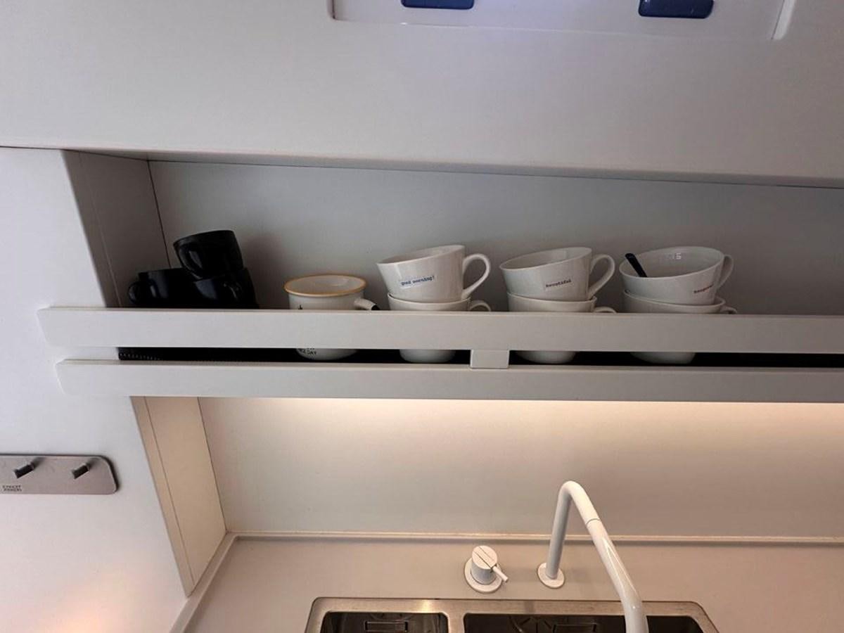 a shelf with many cups on it aboard KARMA Yacht for Sale