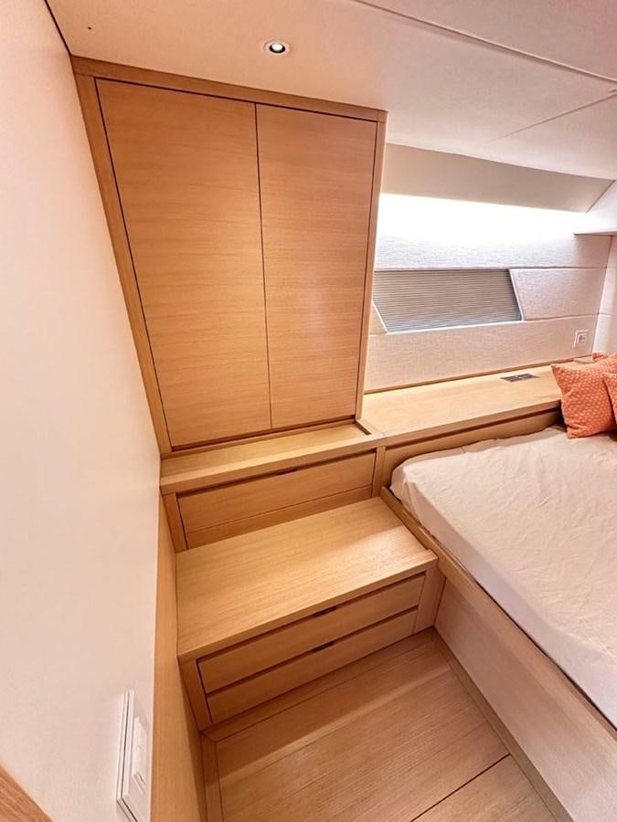 a wooden cabinet above a bed aboard KARMA Yacht for Sale