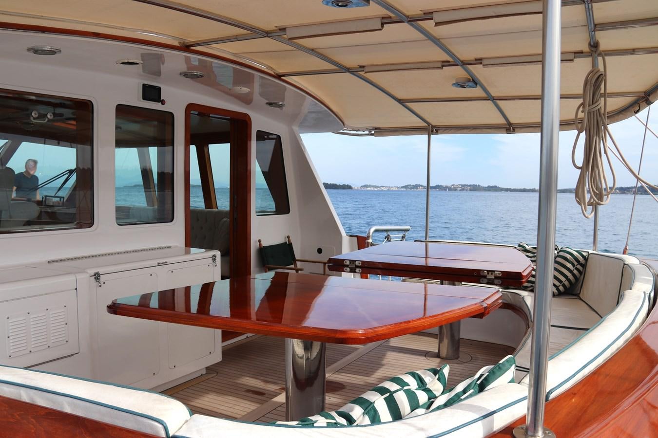 a boat with a bench and umbrellas on it aboard KEEWAYDIN Yacht for Sale