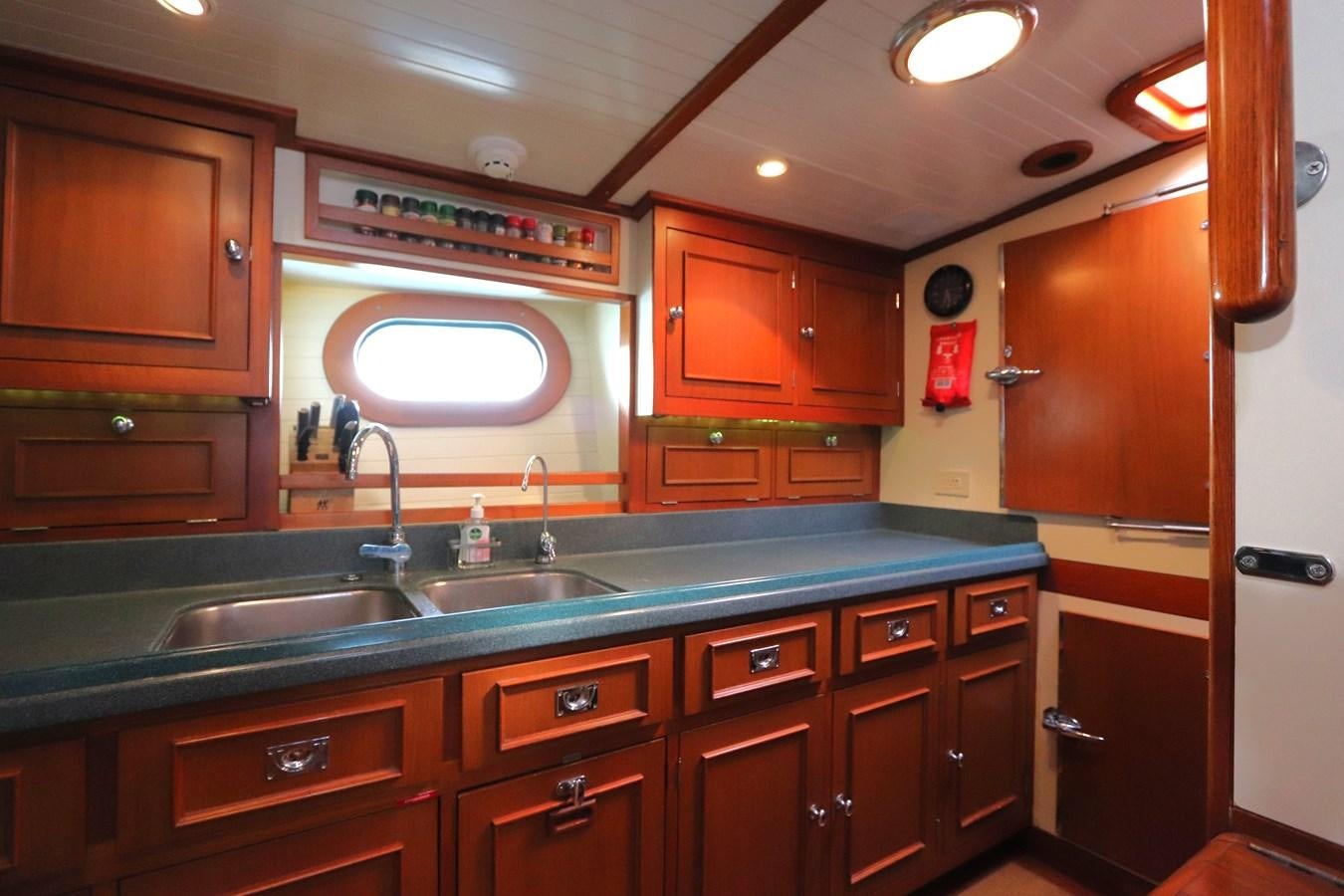 a kitchen with wooden cabinets aboard KEEWAYDIN Yacht for Sale