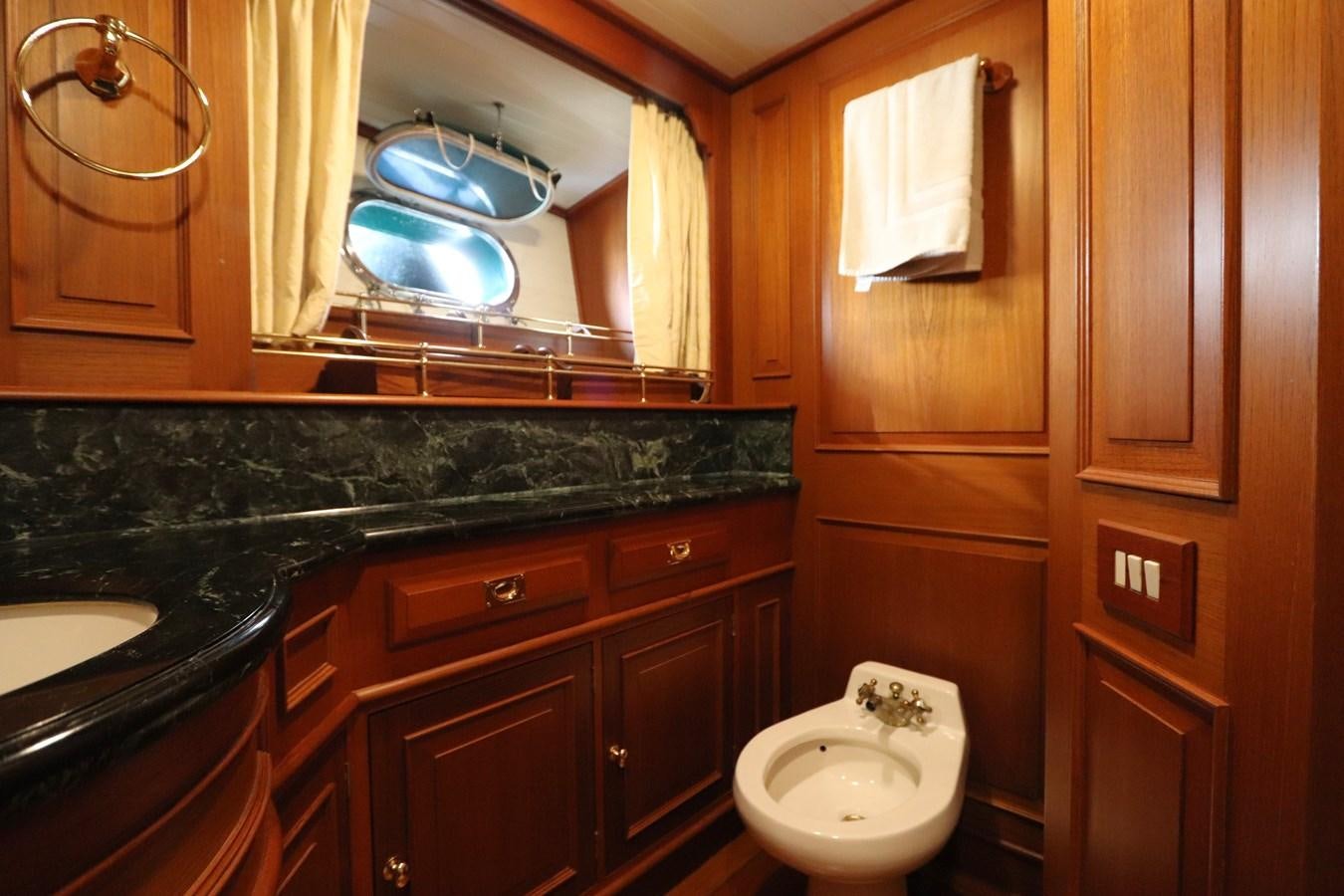 a bathroom with a toilet and cabinets aboard KEEWAYDIN Yacht for Sale