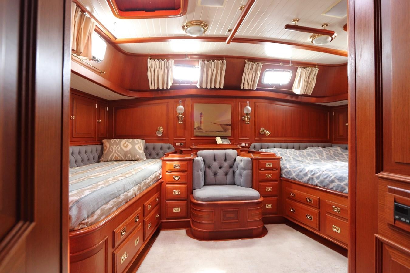 a bedroom with a bed and a chair aboard KEEWAYDIN Yacht for Sale