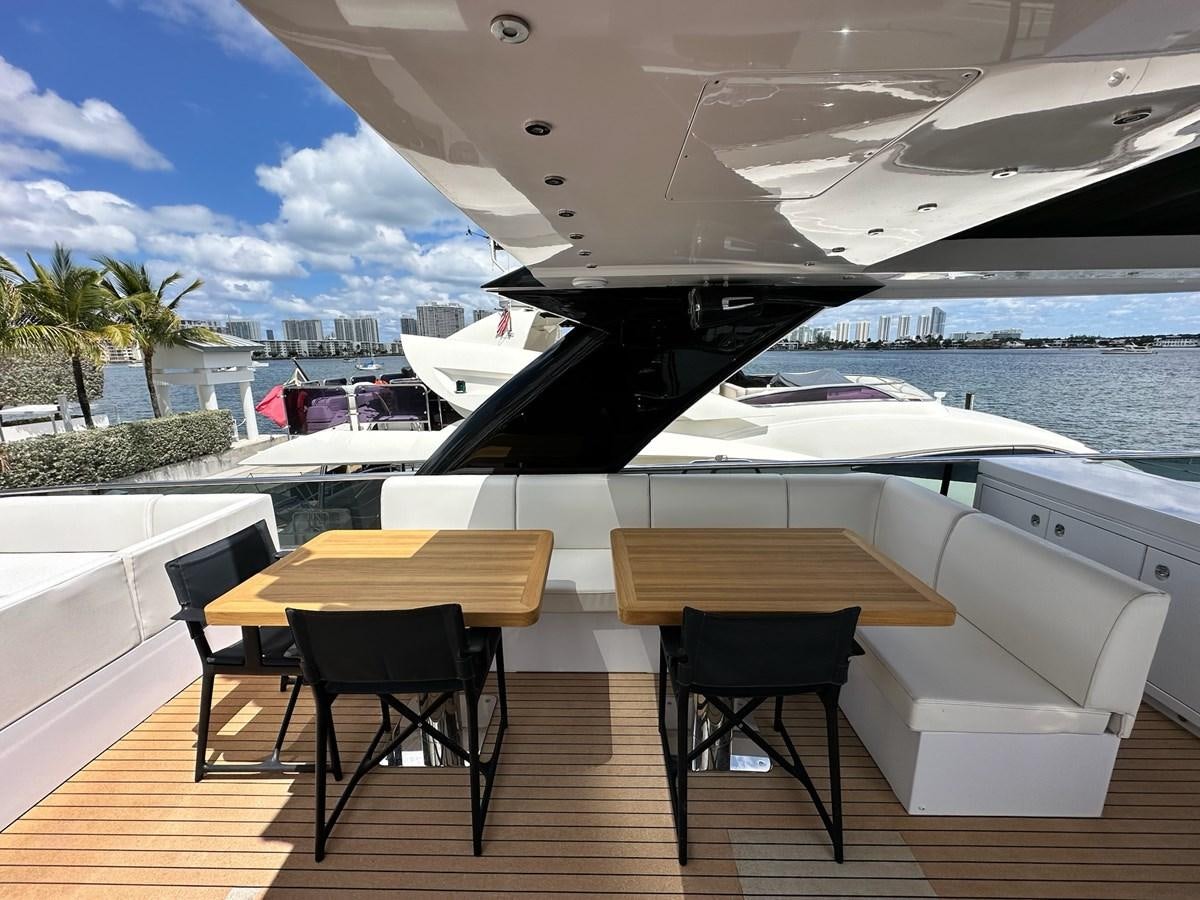 a table and chairs on a deck overlooking a body of water aboard AMER 94 Yacht for Sale