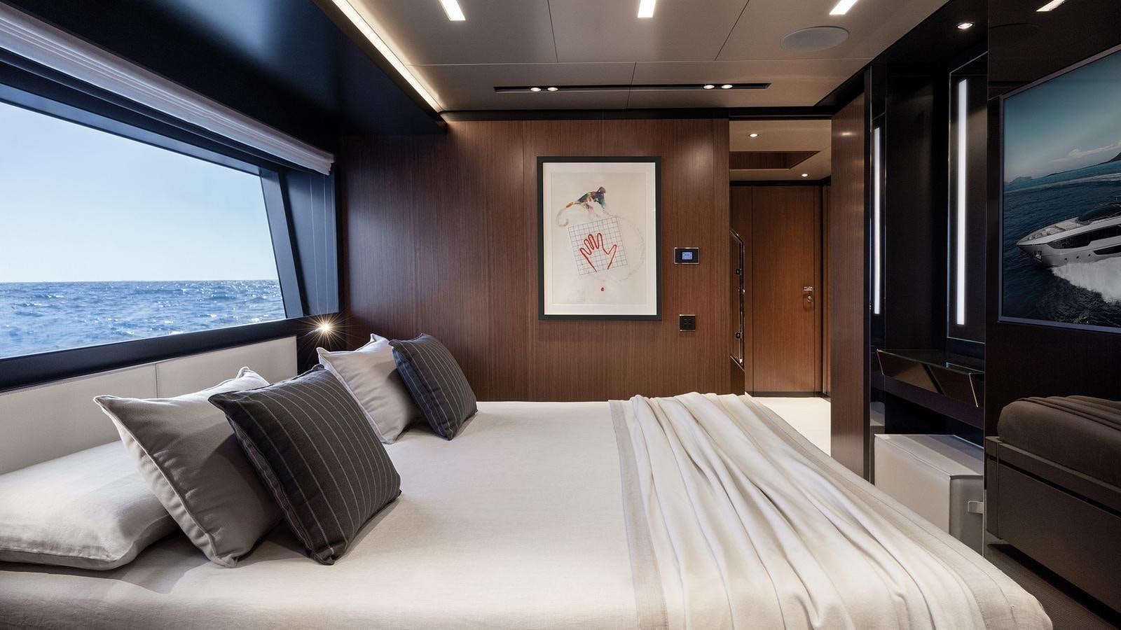 a bed with pillows and a television in a room aboard THREE GRACES Yacht for Sale