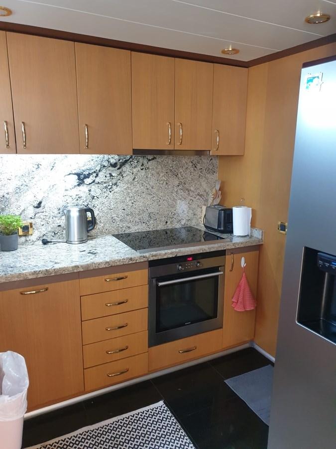 a kitchen with wooden cabinets aboard NIKE III Yacht for Sale