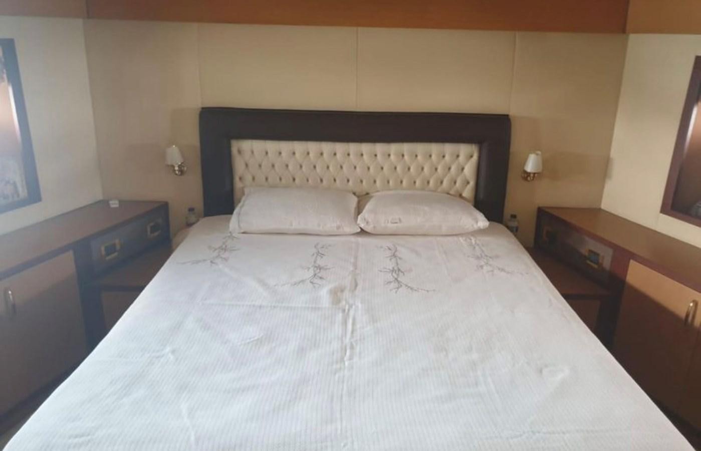 a bed with white sheets aboard NIKE III Yacht for Sale