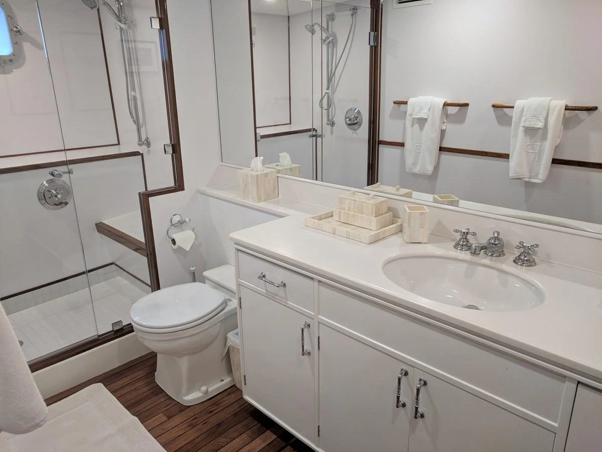 a bathroom with a sink toilet and a mirror aboard BUCKPASSER Yacht for Sale