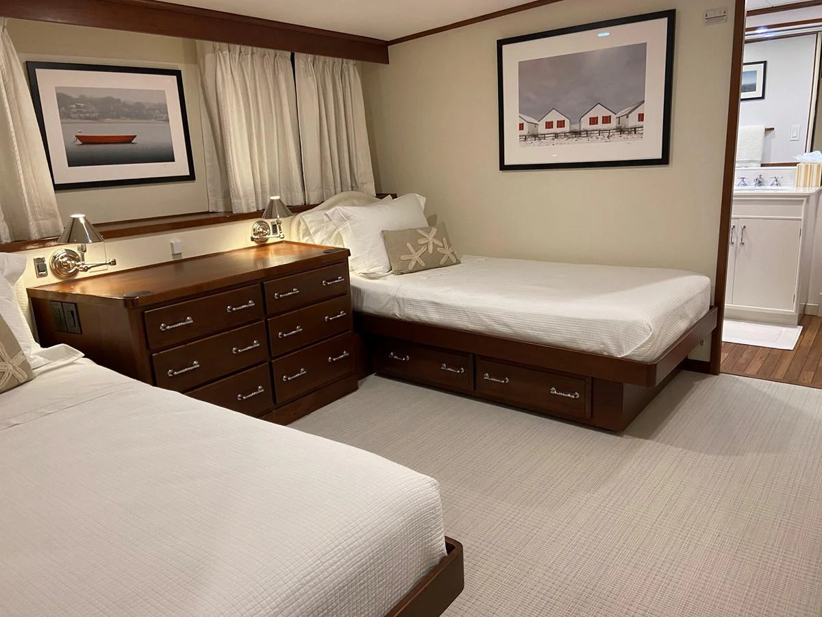 a hotel room with a bed and a dresser aboard BUCKPASSER Yacht for Sale