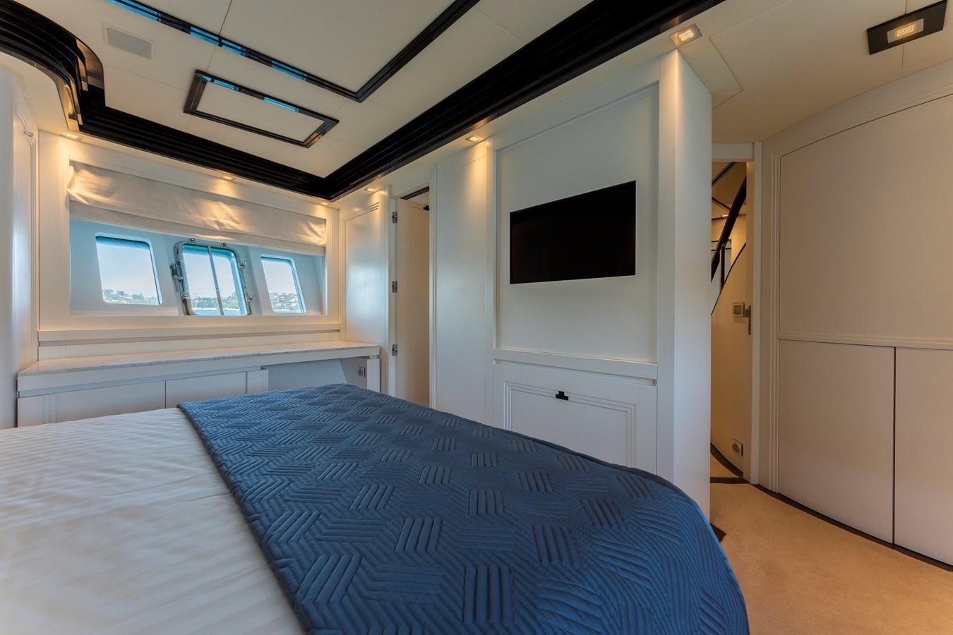a bedroom with a bed and a television on the ceiling aboard DOMUS Yacht for Sale