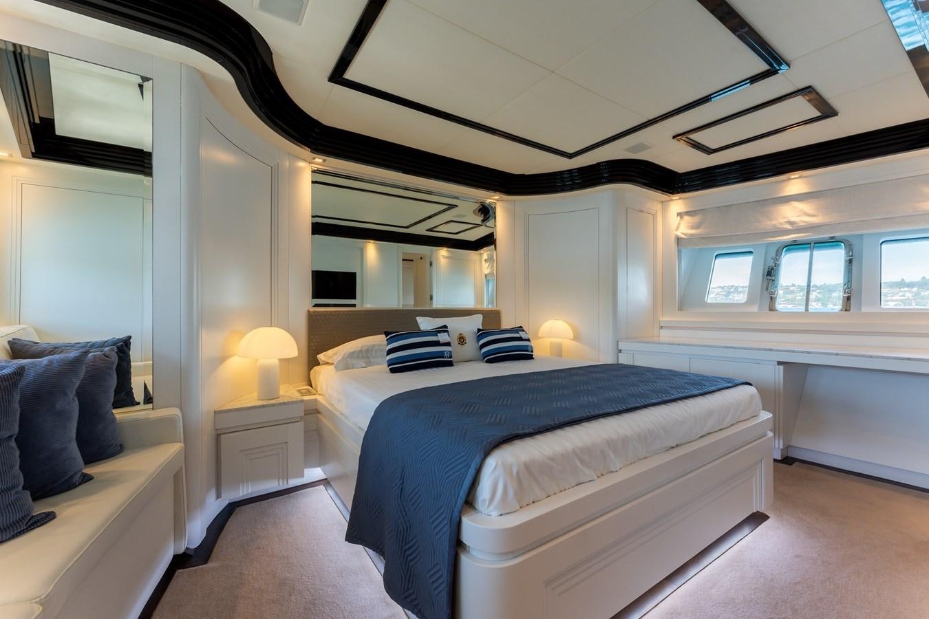 a bedroom with a bed and a window aboard DOMUS Yacht for Sale