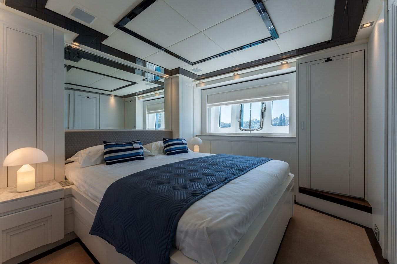 a bedroom with a bed and a window aboard DOMUS Yacht for Sale