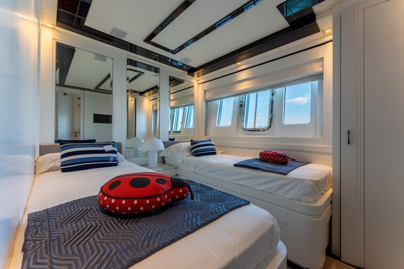 a bedroom with a bed and a red rug aboard DOMUS Yacht for Sale