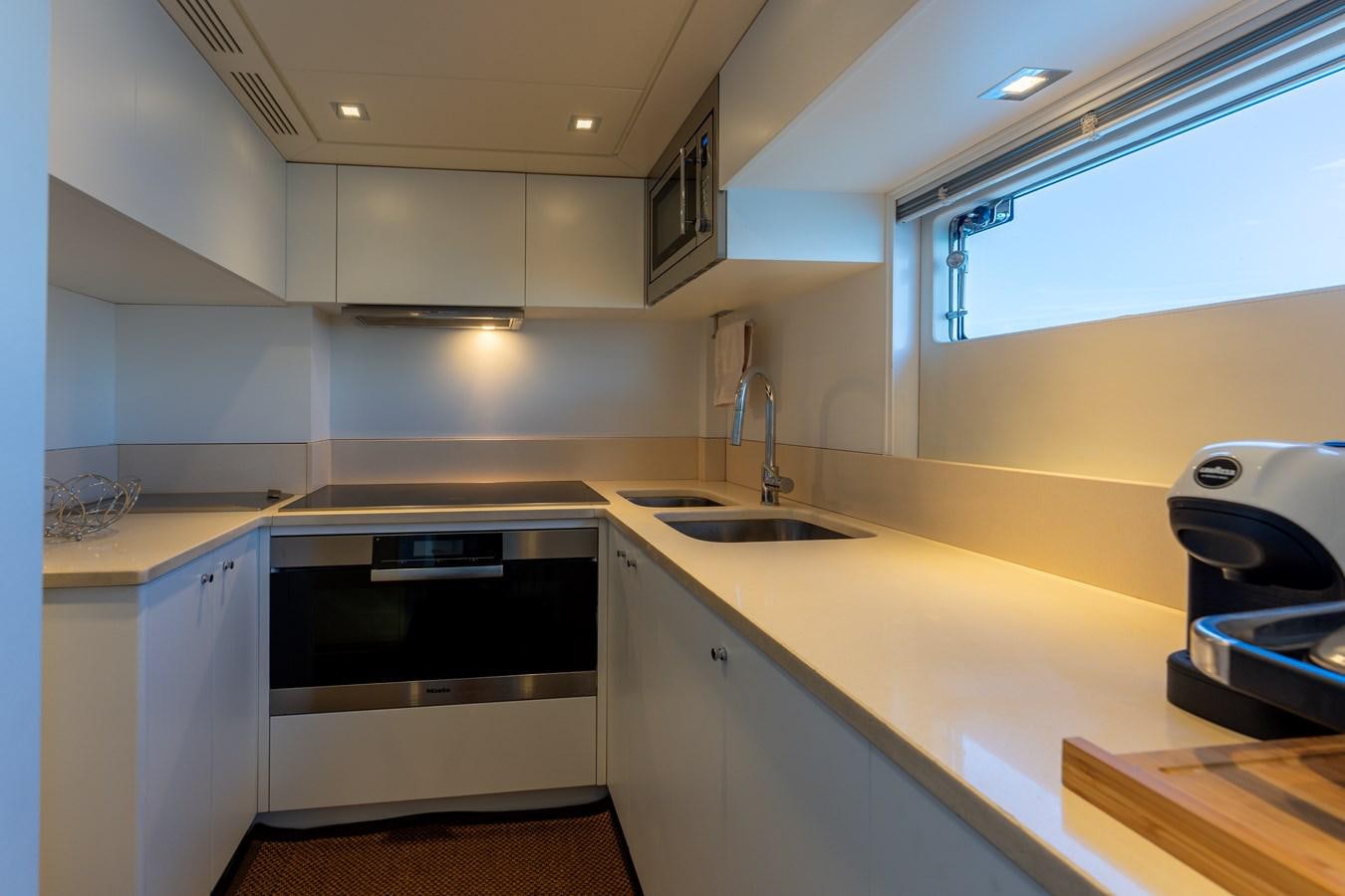 a kitchen with white cabinets aboard DOMUS Yacht for Sale