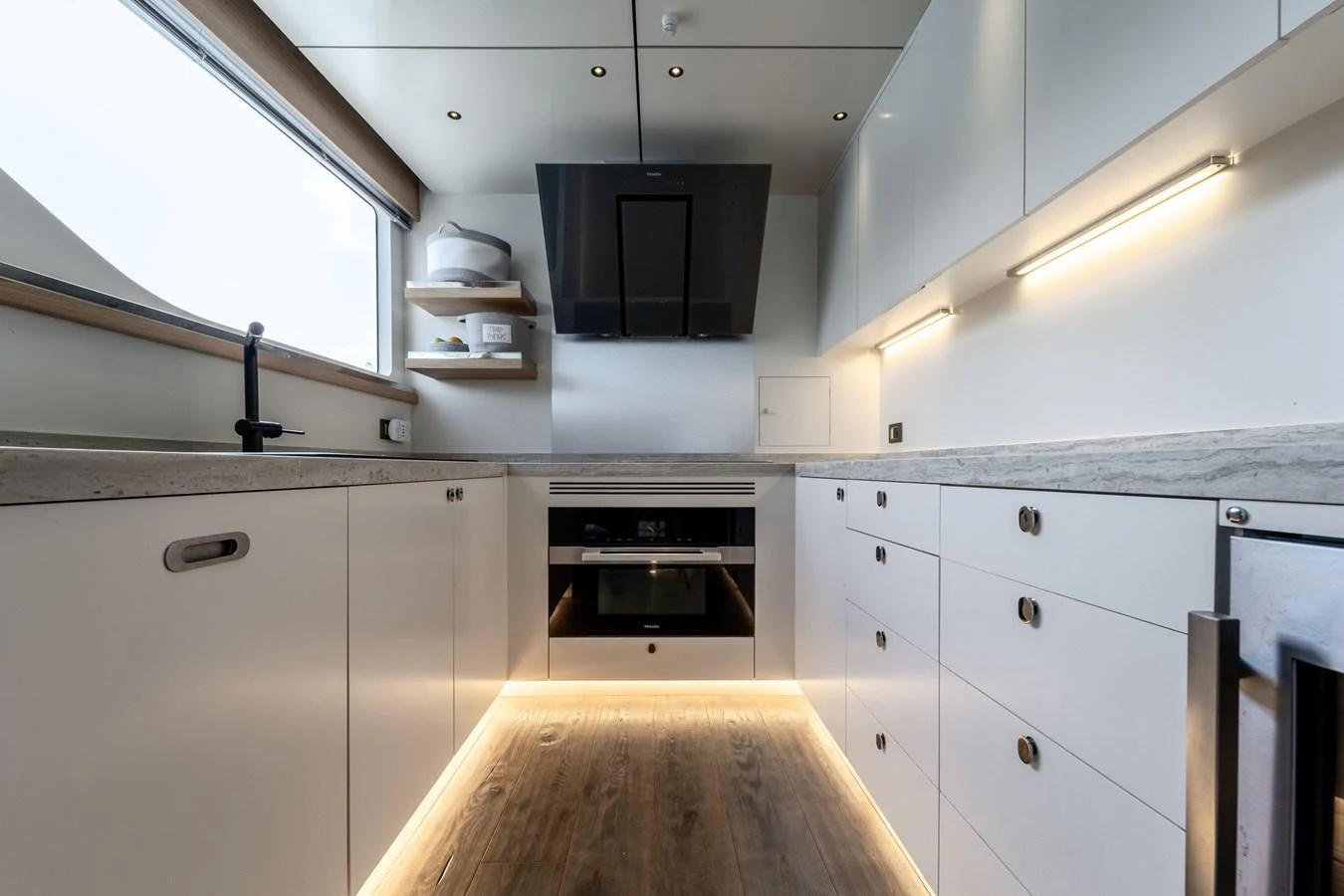 a kitchen with white cabinets aboard EXIT STRATEGY Yacht for Sale