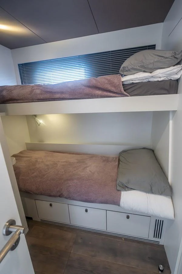 a bed with a window aboard EXIT STRATEGY Yacht for Sale