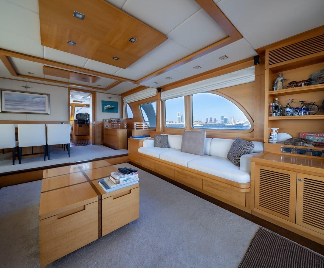 a living room with a large wood table and a large window aboard ANTALYA Yacht for Sale