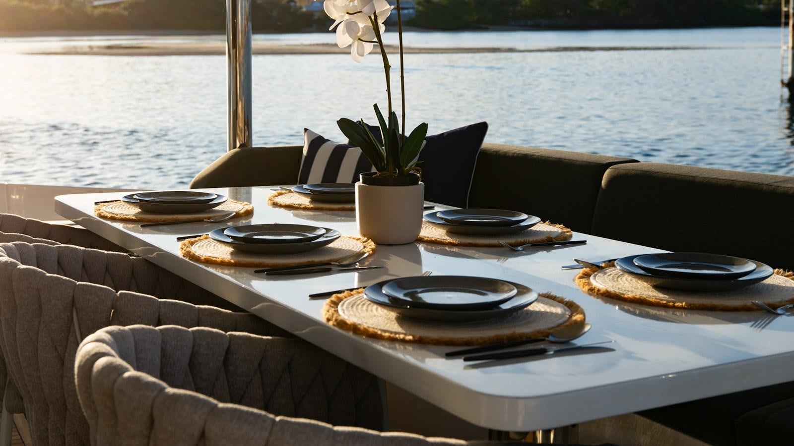 a table with plates and plates on it aboard SOLACE Yacht for Sale