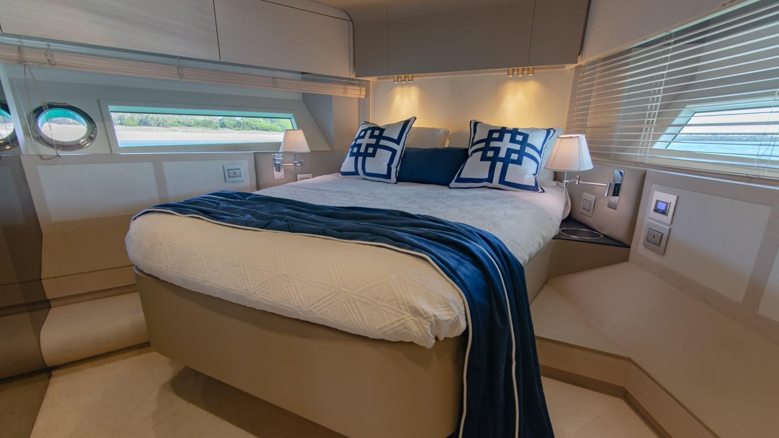 a bed with blue sheets aboard SOLACE Yacht for Sale