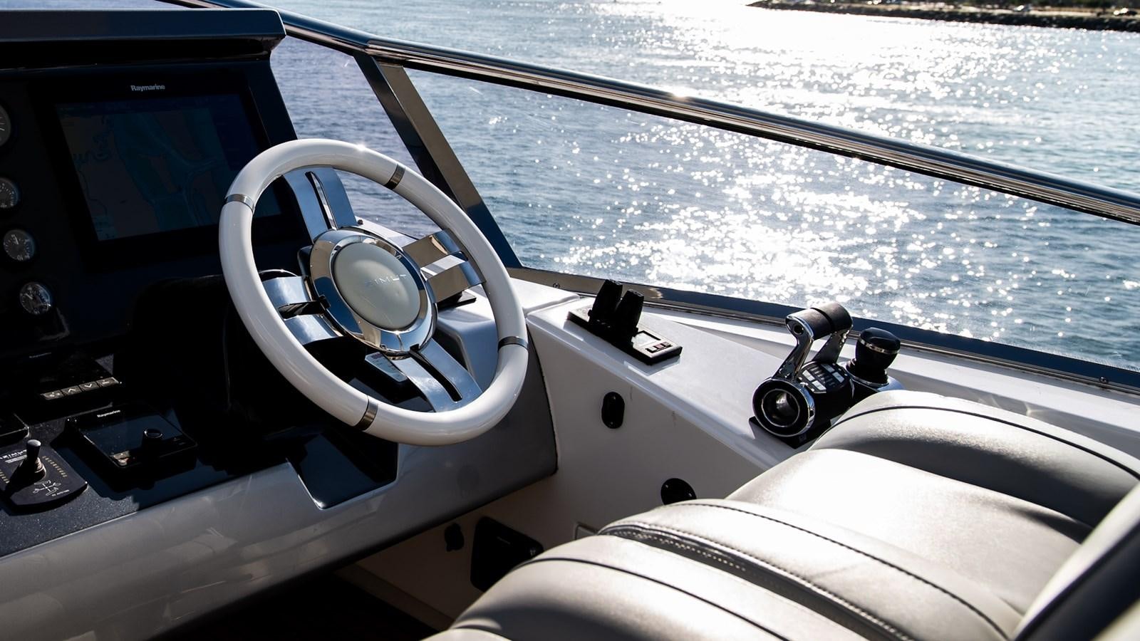 a steering wheel and dashboard of a boat aboard SOLACE Yacht for Sale
