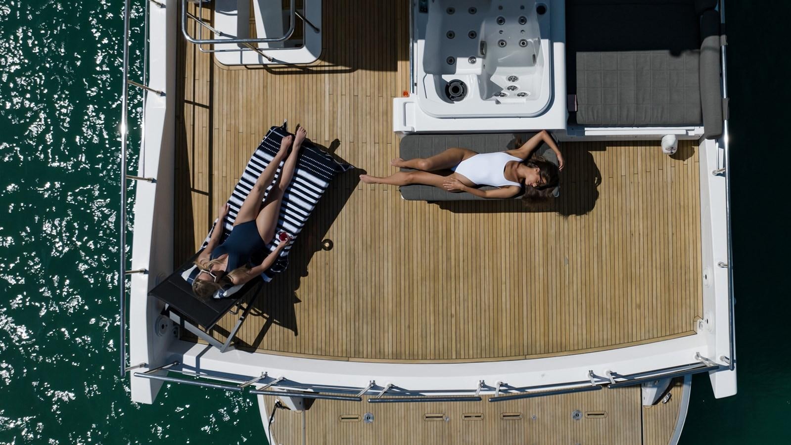 a person sitting on a deck chair aboard SOLACE Yacht for Sale