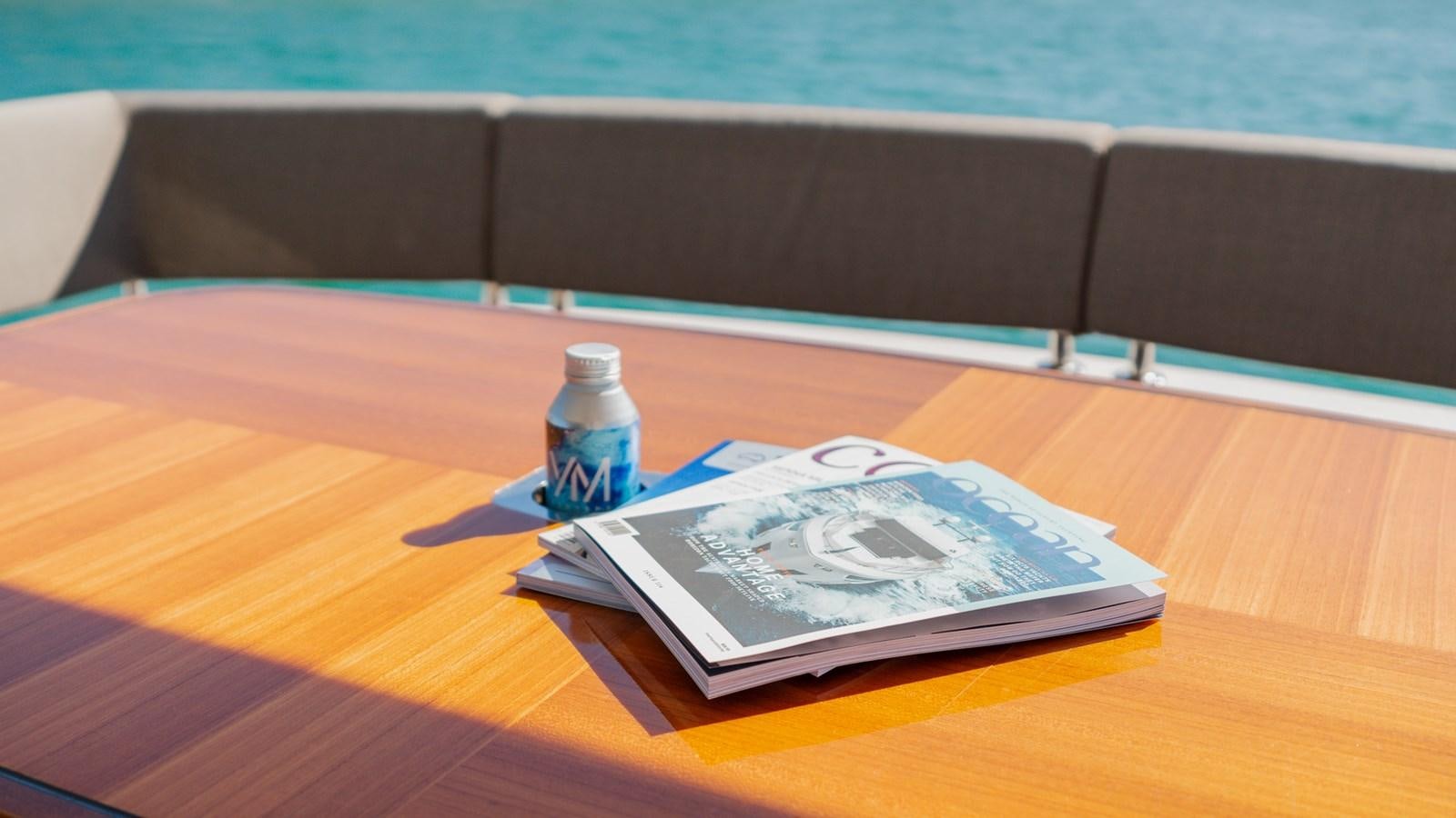 a bottle of water and a game on a table aboard OHANA Yacht for Sale