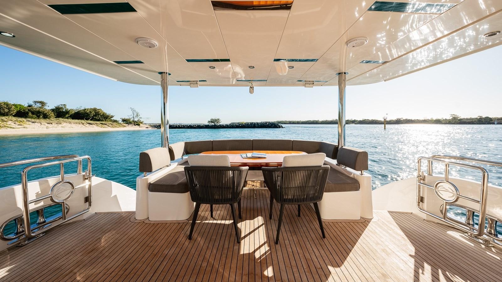 a table and chairs on a deck aboard OHANA Yacht for Sale