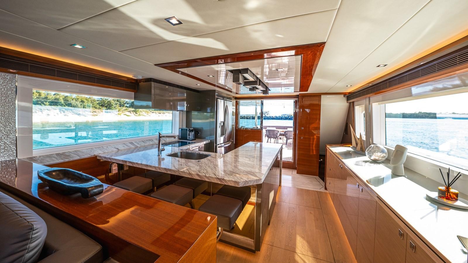 a modern looking living room with a large open window aboard OHANA Yacht for Sale