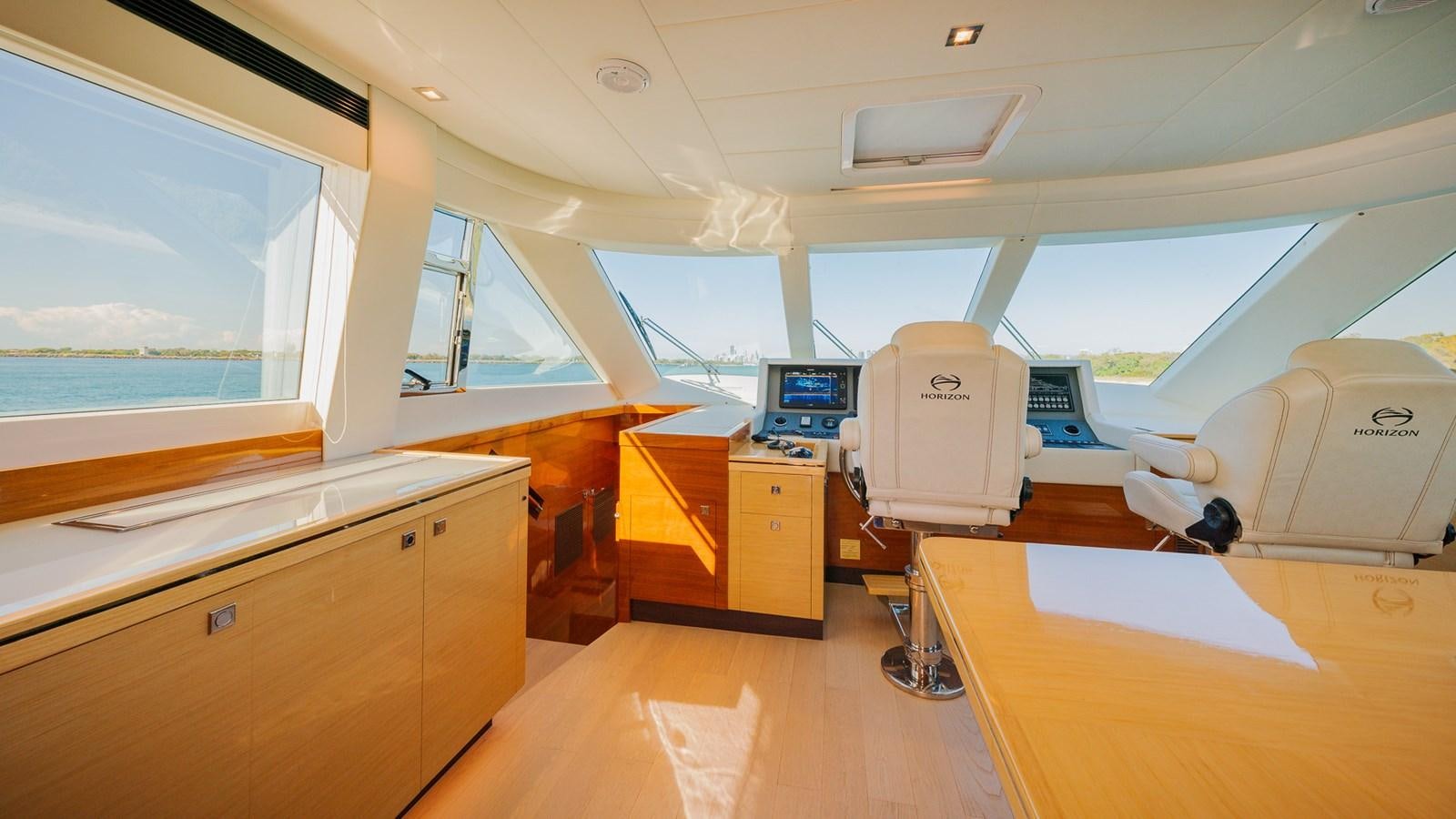 inside of a vehicle with a large window and a desk with computers aboard OHANA Yacht for Sale