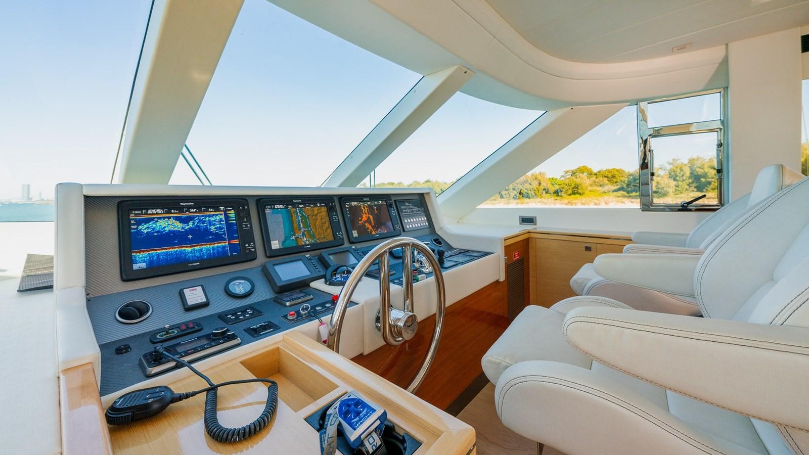inside of a vehicle with a large screen and a couch and a table with a chair and a aboard OHANA Yacht for Sale