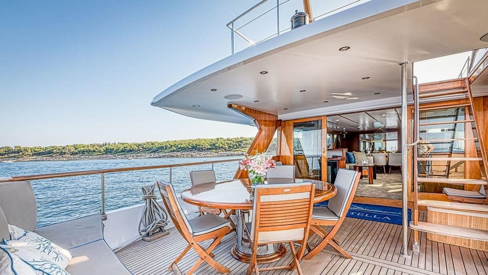 a deck with a table and chairs on it aboard CHANTELLA Yacht for Sale