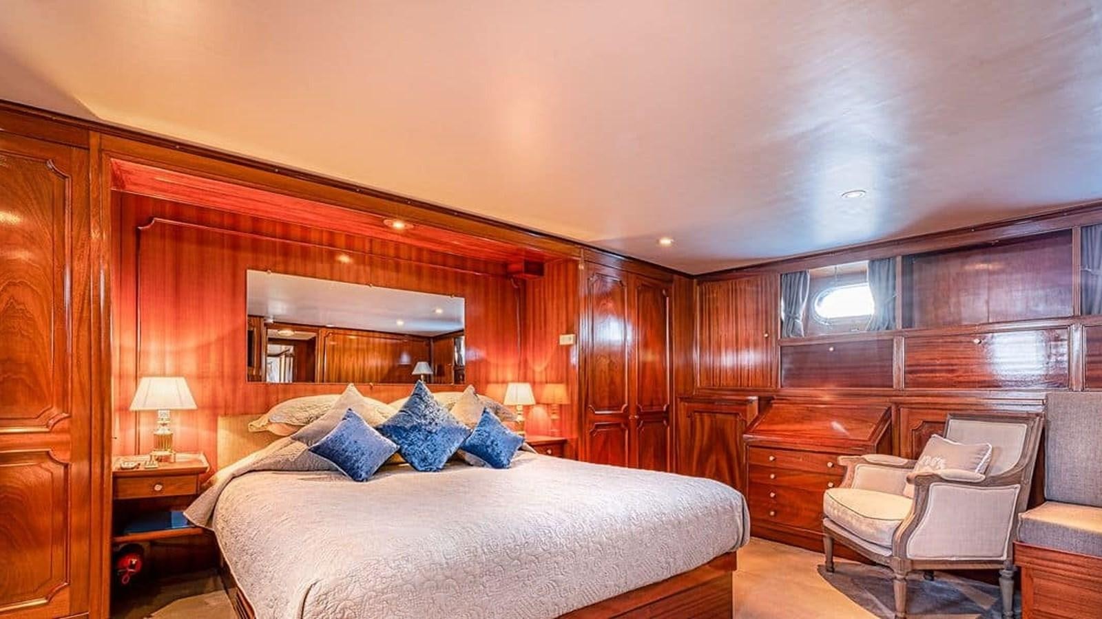 a bedroom with a bed and a chair aboard CHANTELLA Yacht for Sale