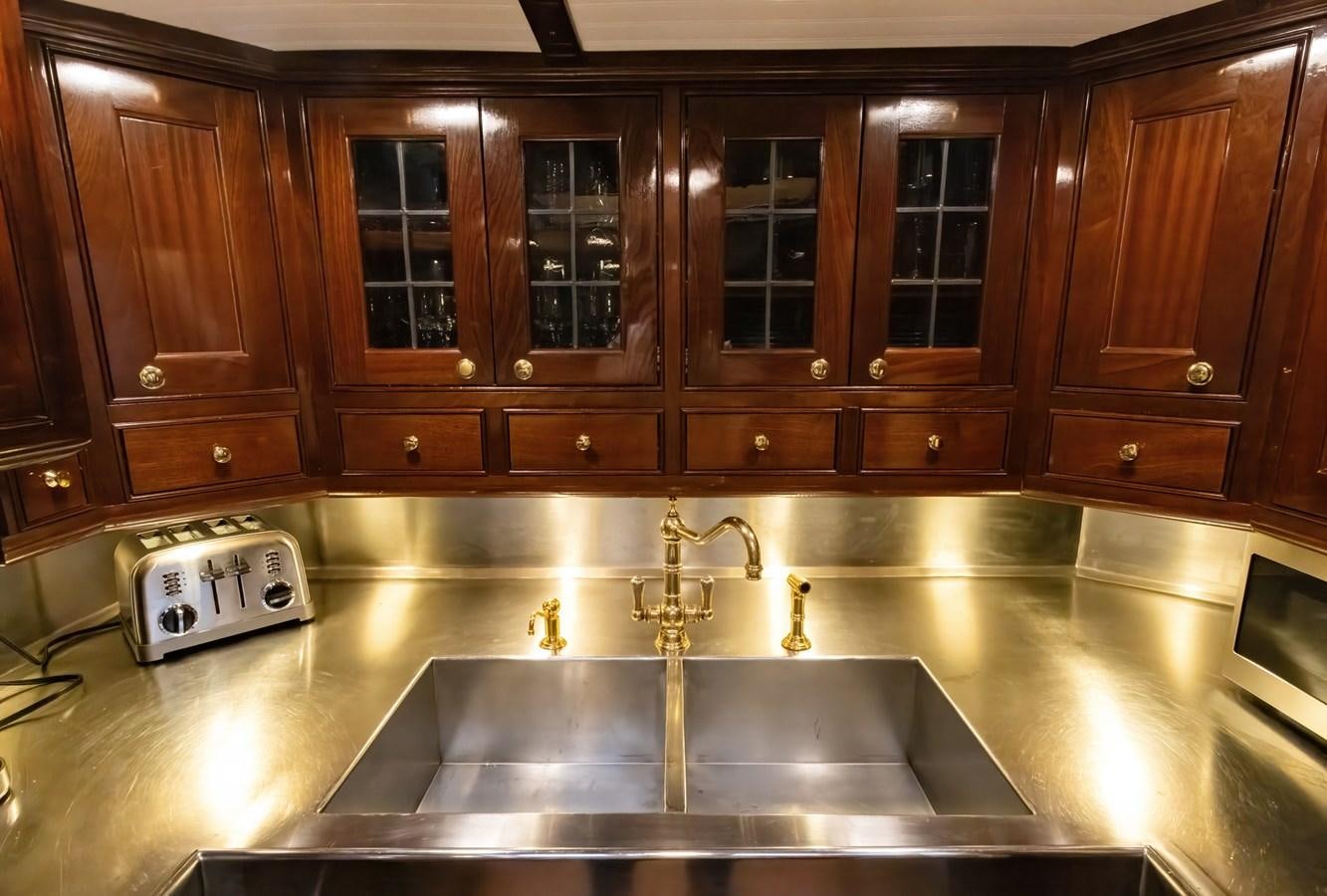 a kitchen with wooden cabinets aboard HERMITAGE Yacht for Sale