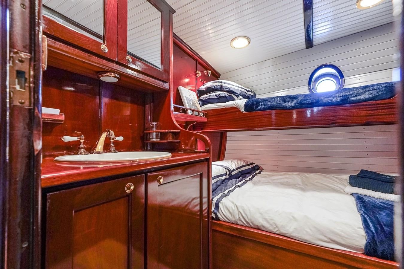 a bed with a sink and a mirror aboard HERMITAGE Yacht for Sale
