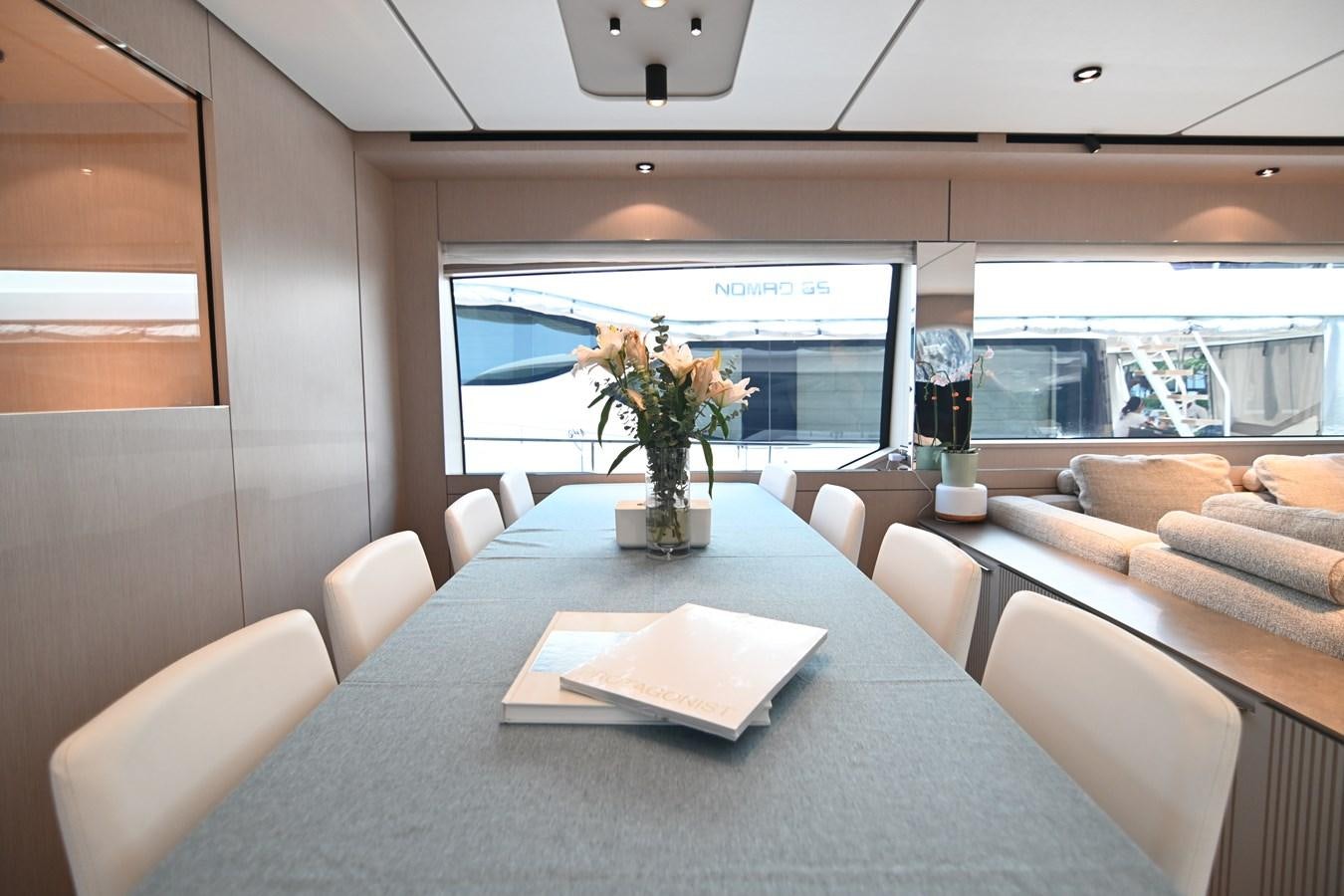 a dining table with a vase of flowers on it aboard JOYOUS JOURNEY Yacht for Sale
