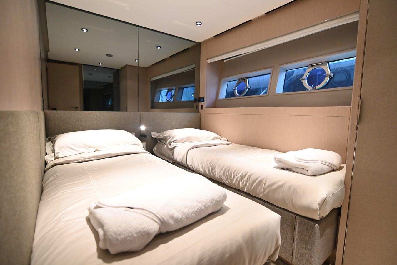 a room with beds and a window aboard JOYOUS JOURNEY Yacht for Sale